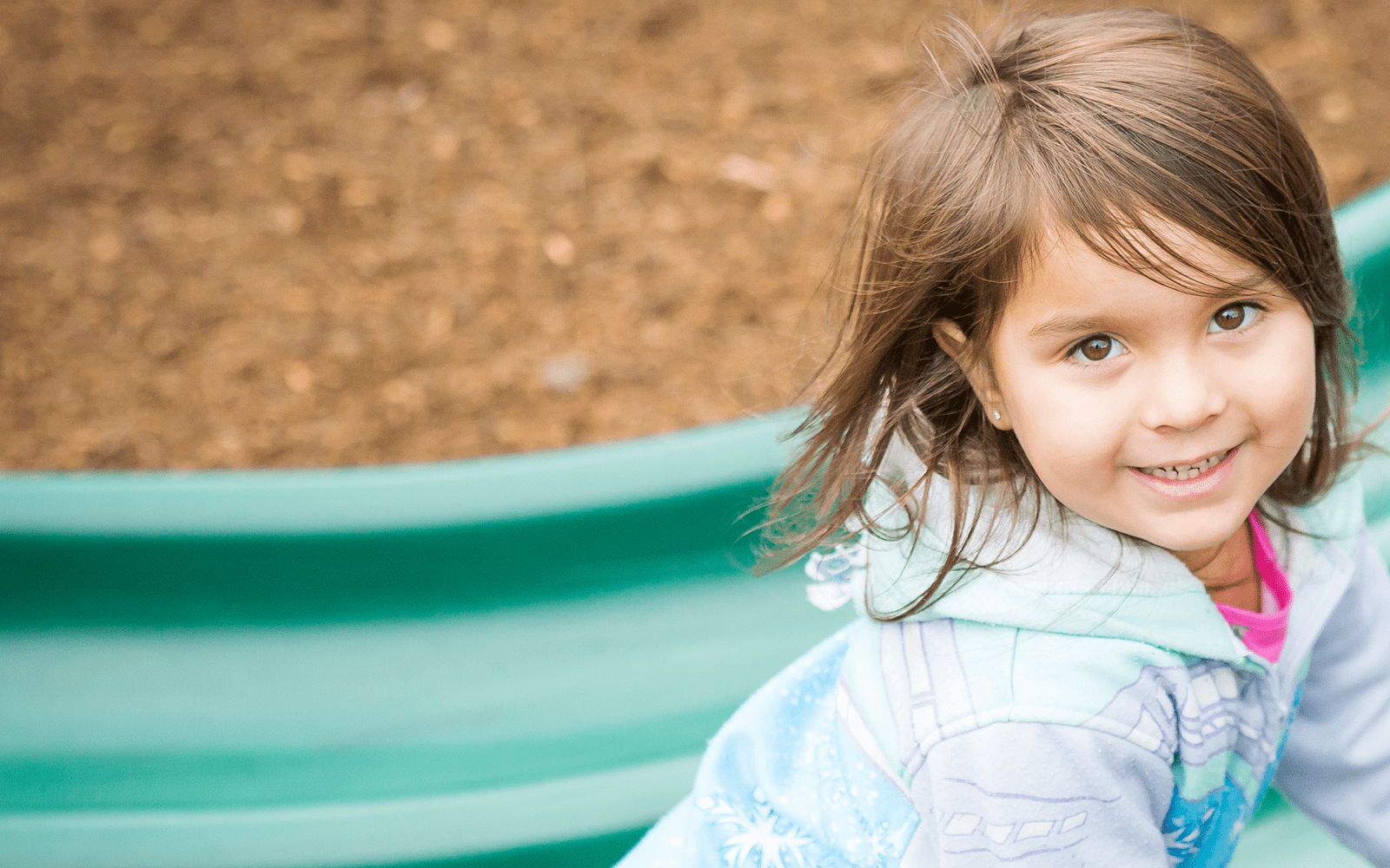 Little girl on slide in playground