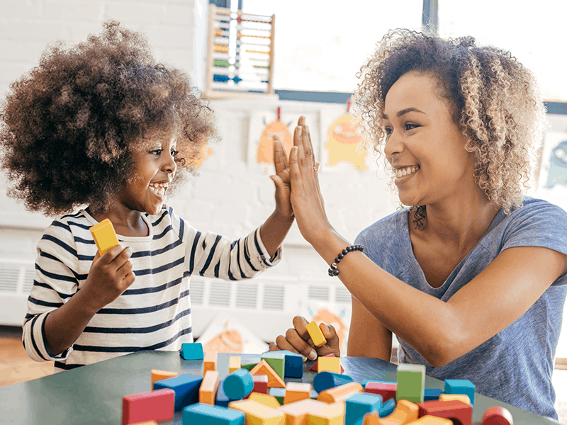 Child and teacher high fiving